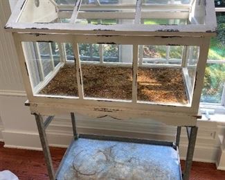 Lot 9037.  $225.00. This is a Unique Shabby Chic Greenhouse/plant holder atop a galvanized steel shelf on a legged tray.  53" tall, 19" deep and 31" wide.  This would be a great piece to start seeds in, display plants, or even would make an interesting miniature garden or display.  Stone Figurines and plants not included. Love this piece!  Shown as you would purchase with out contents
