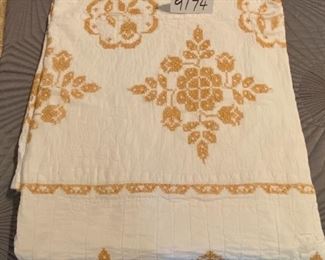 Lot 9174.  $75.00. Vintage white with gold cross stitch design, hand stitched quilt. 	64" W x 88" L