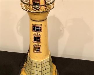 Lot 9121.  $25.00 Cute metal, decorative lighthouse with cut-out windows and a ladder in relief on one side.  	21" T on 9" diam base