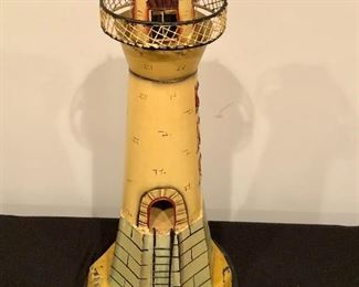 Lot 9121.  $25.00 Cute metal, decorative lighthouse with cut-out windows and a ladder in relief on one side.  	21" T on 9" diam base
