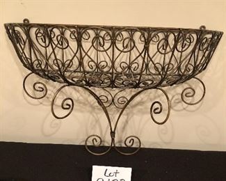 Lot 9133.  $50.00 2 red pots with attached saucers (6.5" diam x 5.5" T), made Portugal, and a wire hanging wall plant basket (23" W x 9.5" D x 15" T)