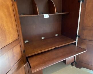 Lot 9171. $475.00.  Sligh Homeworks office/computer/ armoire/workstation, with a wood stained finish.  The large internal workspace includes keyboard drawer and storage. When you are finished with your project, the desk can be hidden away behind two large doors.	48.25" W x 71.5 T x 23.75" D