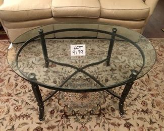 Lot 9179.  $330.00 Wrought iron frame and 1" thick glass on this oval shaped coffee table.  This is a wonderful piece and so heavy, the glass won't budge even when we try to slide it..
