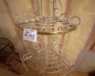Lot 9198. $50.00. Up for sale is an attractive, heavy metal, corner triple shelf.  It has a white finish with brass trim and accents.  Great storage for a small space.	25"W x 64" T x 16"D.  Plants look terrific on these corner shelve as well.