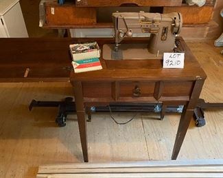 Lot 9210. $165.00 Vintage Singer Model 328K Stylomatic Singer Sewing machine in cabinet.  Includes original metal attachments and some sewing notions and bench seat.26" W x 17" D 