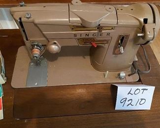 Lot 9210. $165.00 Vintage Singer Model 328K Stylomatic Singer Sewing machine in cabinet.  Includes original metal attachments and some sewing notions and bench seat. 26" W x 17" D 