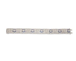 1016
An Art Deco Diamond And Sapphire Bracelet
Circa 1925, Platinum
Centering on seven full-cut round diamonds, totaling 1.4cts, and further set with two hundred forty-five single and full-cut round diamonds, totaling approximately 9.5cts and graded G-H color and VS clarity, further set with small calibre-cut sapphires
7.25" L x .75" W
35 grams
Estimate: $8,000 - $12,000