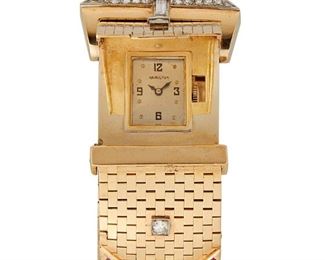 1138
A Retro Hamilton Gem-Set Buckle Covered Wristwatch
14k yellow gold
Dial: Rectangular silvered dial, Arabic and dot hour markers, signed Hamilton
Movement: 17 jewel stem wind and set manual movement, Cal: 911, #T10 7960, singed Hamilton / U.S.A.
Case/Bracelet: 14k yellow gold case and retro bracelet, hidden spring activated lid revealing watch, bracelet set with one baguette and eighteen single and full-cut round diamonds, totaling approximately .4ct and graded G-H color and SI clarity, further set with baguette-cut simulated rubies
6.75" L x 1" W
97.5 grams
Estimate: $2,500 - $3,500