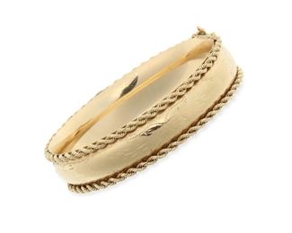 2037
A Gold Hinged Bangle Bracelet
14k yellow gold
Designed with a foliated engraving on polished gold flanked by ropework frame
6.75" C x .5" W
27.6 grams
Estimate: $800 - $1,200