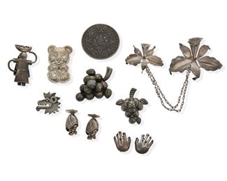 2176
A Group Of Mexican Silver Jewelry
Comprising a pair of Antonio Pineda clip-back hand earrings, stamped: crown mark for Antonio Pineda / Eagle 3, further stamped: 970; a Hector Aguilar twin floral brooch with chain connection, stamped: HA mark for Hector Aguilar / Taxco / .940; a Fred Davis fruit basket figure brooch, stamped: FD mark for Fred David / Made in Mexico / Silver; a pair of blanketed figures in sombreros, each stamped: 925 / LZ / Guad Jal; a bear pendant/brooch, stamped: 925 / Mexico; two grape cluster brooches; a serpent brooch; and a Mexican Aztec calendar pendant/brooch, 11 pieces
Aztec calendar brooch: 2.25" D
178 grams gross
Estimate: $500 - $700