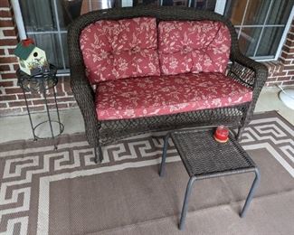 Outdoor wicker loveseat furniture and rug