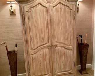 Armoire by Davis Cabinet Company along with Pair of Metal Umbrella Stands