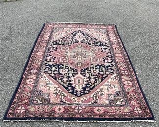 GEOMETRIC MEDALLION RUG | Pink medallion on a blue ground with a salmon border with rosettes and leaves [fringe worn, otherwise appears to be in good condition]; 9 ft. 2 in. x 5 ft. 5 in. 
