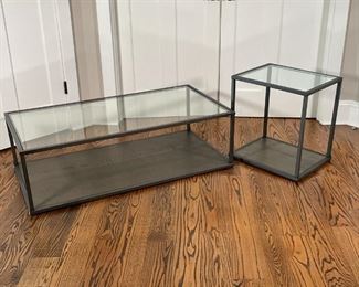 (2pc) STEEL & GLASS TABLES | A matching set with painted wood lower shelf and glass top with matte steel frame, including a low / coffee table (h. 14 x w. 48 x d. 25 in.) and a side table or end table (h. 21 x w. 16 x d. 20 in.) 