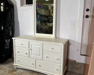 RAGAZZI VANITY CONSOLE | Vanity table with four drawers flanking a central cabinet door over two drawers, with outset columns and overall distressed white paint; cabinet h. 33 x w. 54 x d. 20 in.; with a removable mirror (42 x 27 in.) 