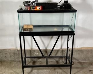 GLASS TERRARIUM on STAND | Plate glass terrarium with a mesh top on a conforming metal stand with a lower shelf, plus a heat lamp, liquid level, etc.; tank h. 12 x w. 30 x d. 12 in.; overall h. 42 in. 
