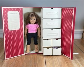 AMERICAN GIRL DOLL & ACCESSORIES | An American Girl Doll with heart-shaped earrings [and a later, modern haircut] in a wardrobe box with clothes and accessories; box h. 21 x w. 16-1/2 x d. 5-1/2 in. 