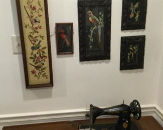Antique sewing machine in wood cabinet.   Bird themed pictures and needlepoint.