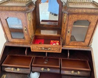 Slant Front Desk from 19th Century France with Center raised mirror flaked by compartments, Bronze Gallery and mounts, pigeonholed interior having four compartments with 3 drawers and leather writing area.  Bought from London and appraised at $8,000 in 2008. 60x100x18.