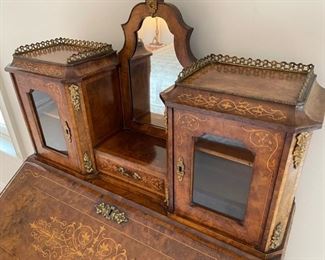 Slant Front Desk from 19th Century France with Center raised mirror flaked by compartments, Bronze Gallery and mounts, pigeonholed interior having four compartments with 3 drawers and leather writing area.  Bought from London and appraised at $8,000 in 2008. 60x100x18.