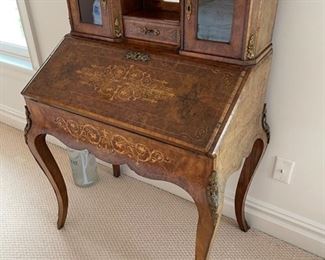 Slant Front Desk from 19th Century France with Center raised mirror flaked by compartments, Bronze Gallery and mounts, pigeonholed interior having four compartments with 3 drawers and leather writing area.  Bought from London and appraised at $8,000 in 2008. 60x100x18.