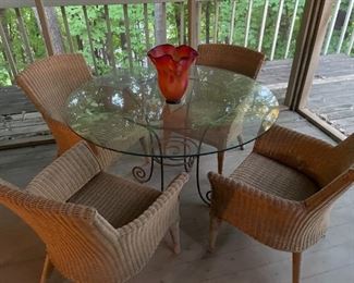sunroom table with rattan chairs, there is also a wooden patio table with chairs on the outside balcony