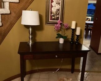 . . . a nice foyer table with brushed-nickel lamp along with orchid and candle accents