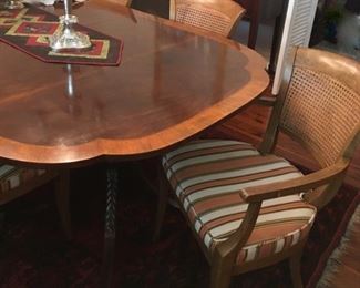 Dining room table by Baker, 46"W x 101.5" L, including two 16-inch leaves.  Includes table pads;  2 armchairs, 6 side chairs with caned back and upholstered seat.