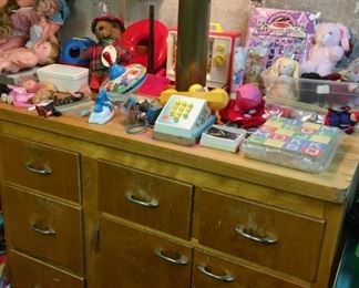 Cabinet with butcher block top. Vintage Tonka, Matchbox cars, action figures, Playmobil figures, including 1974 Geobra. Playmobile cowboy toys. Army figures, vehicles. Several Fisher Price toys including Pull-A-Tune, airplane, school bus, radio, pocket camera, parking garage, figures, vehicles, Roly Poly. Legos. 1960s-1970s toys.