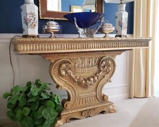 One of two, gold tone pedestal console table, approximately 50 inches wide by 18 inches deep by 30 inches tall