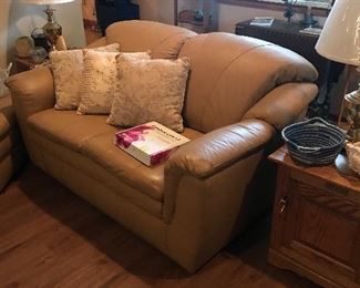 Leather loveseat has matching ottoman. Flanked by matching end tables that look like vintage wooden iceboxes! Pair of matching table lamps!