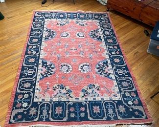 CHINESE STYLE FLAT WOVEN RUG | Area carpet with salmon ground, having a central medallion with floral devices, within a navy border within an outer salmon border; 8 ft. 1 in. x 5 ft. 2 in. 