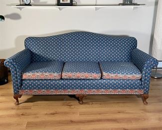 CAMELBACK SOFA | Three cushion sofa with unique floral upholstery having a pattern of red flowers on a blue ground with decorated floral borders, with carved shell knees on short cabriole legs, appearing in overall good condition, as pictured- comfy! h. 35 x w. 72 x d. 34 in. 