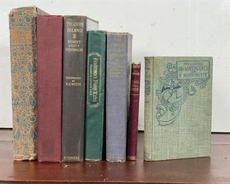 (7vol) CHILDREN'S STORIES | 1920s and earlier bindings, including: "Pinocchio: The Adventures of a Marionette" by C. Collodi with illustrations by Charles Copeland (pub. Ginn and Company, 1904); "Travels With a Donkey in the Cevennes" by Robert Louis Stevenson (pub. London, Chatto & Windus, 1920); Hans Christian Andersen "Fairy Tales" illustrated by Arthur Szyk (pub. Grosset & Dunlap, New York); "The Three Mulla-Mulgars" by Walter de la Mare, illustrated by Doroth P. Lathrop (pub. Alfred A. Knopf, 1925); "Treasure Island" by Robert Louis Stevenson, illustrated by N.C. Wyeth (pub. Scribners, 1927); "Number Two Joy Street" (pub. D. Appleton and Company, 1924); and Robinson Crusoe by Daniel Defoe, illustrated by N.C. Wyeth (pub. Cosmpolitan Book Corporation, 1920) 