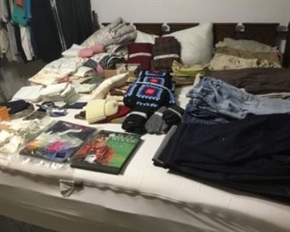 Bedroom - lots of loose men’s shorts, pants, etc on king size bed