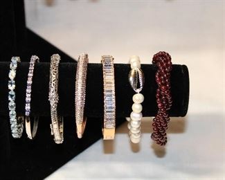 Detail of large assortment of contemporary sterling silver and semi precious gemstone bracelets, bangles, and cuffs including opals, amethysts, pearls, turquoise, black spinels, apatite, and garnets.