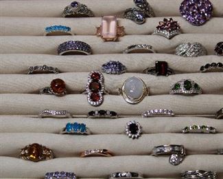 Detail of contemporary sterling silver and gemstone rings including moonstone, garnet, amethyst, turquoise, black spinel, pearl, and green apetite.