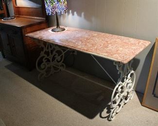 Wrought iron base with pink marble top patisserie style table, 54" long, 23" deep, 27 1/2" tall