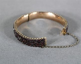 4th Quarter of the 19th c., rose cut Bohemian garnets in a hinged bangle bracelet with a safety chain