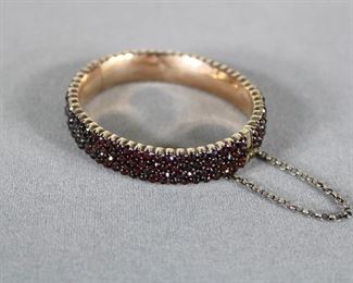 4th Quarter of the 19th c., rose cut Bohemian garnets in a hinged bangle bracelet with a safety chain, gold filled.