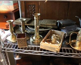 Several pairs and singles of antique brass candlestikcs and a large brass Lion doorknocker!