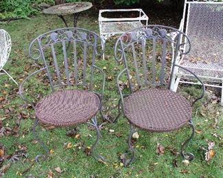 Pair of iron patio chairs with woven seats