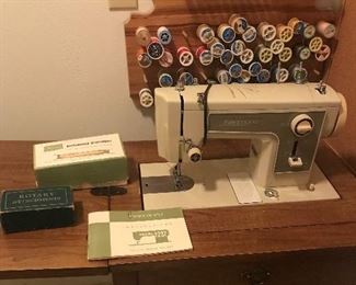 Singer Sewing Machine with instruction manual, button hole attachment, extra belts, needles, bobbins. 