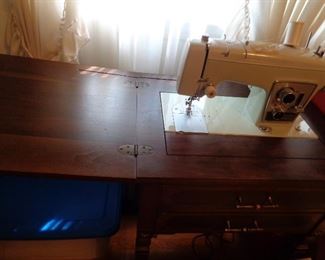 vintage Sears sewing machine in table with chair
