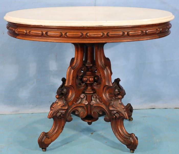 68 - Walnut Victorian ova center parlor table by T. Brooks with white marble, 29 in. T, 37 in. L, 29 in. D.