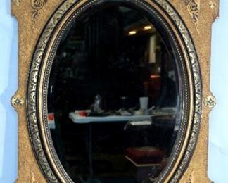 32 - Hanging Victorian beveled oval mirror with gold gilded frame, 53 in. T, 34 in. W.
