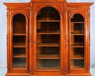 80A - Walnut Victorian 3 door bookcase with rounded top doors and column front, 73 in. T, 77 in. W, 19 in. D.