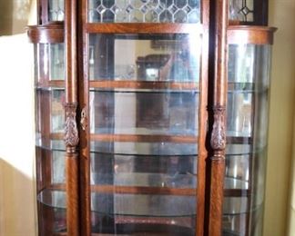61 - Tall quarter sawn oak china cabinet with bow front, leaded glass doors, curved glass ends, full column front, carved crown and claw feet, 80 in. T, 50 in. W, 19 in. D.