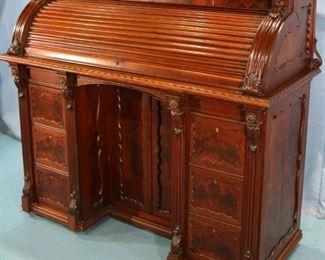55 - Roll top walnut Victorian desk with fitted interior and carved man and woman heads, 50 in. T, 56 in. W, 24 in. D.