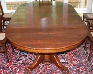 63 - Quarter sawn oak dining table with carved base and claw feet, 27.5 in. T, 100 in. L, 54 in. W.